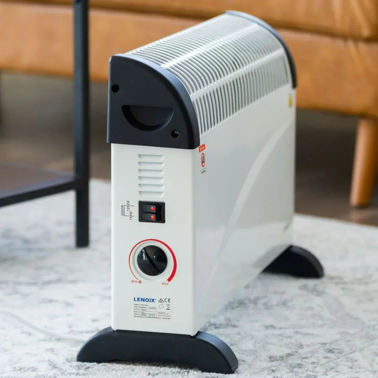 Convection heater on a carpeted floor with a blurred sofa in the background