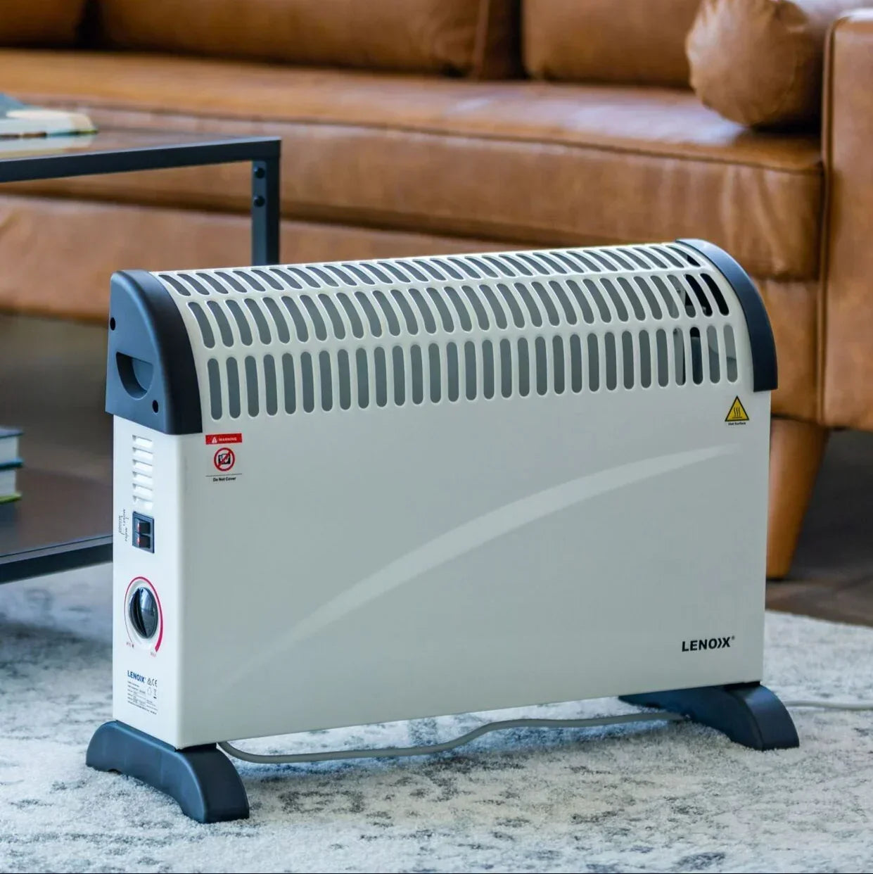 Convection heater on a carpeted floor with a brown leather sofa in the background