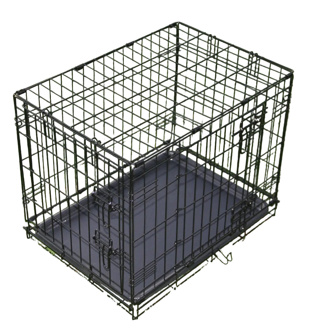 Black metal dog crate on a grassy background