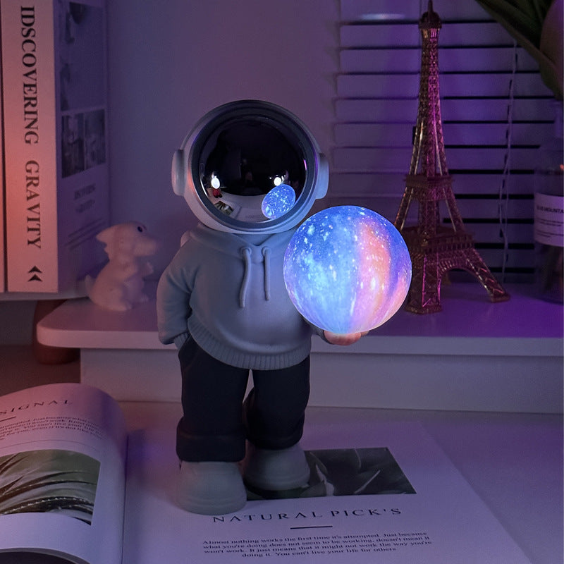 Holding the dreamy starry sky grey top + navy blue pants Creative Astronaut Bluetooth Speaker with 3D Starry Sky Lighting, Portable Wireless Moon Lamp Speaker  Perfect Gift for Space Enthusiasts
