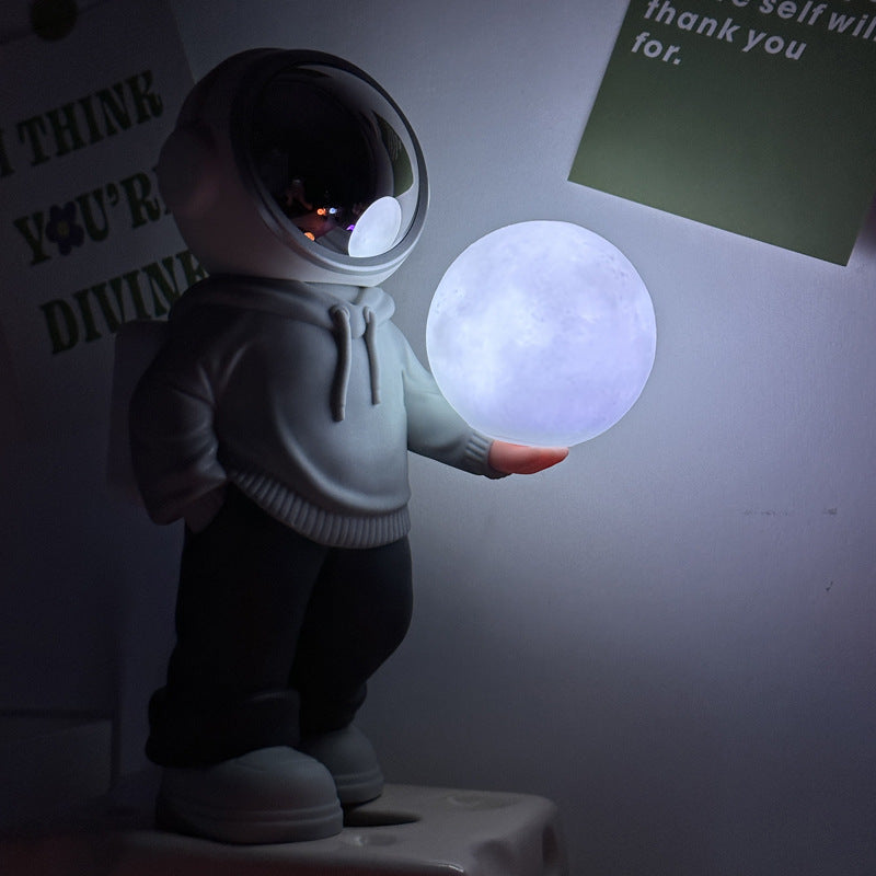 Holding the romantic moon grey top + navy blue pants Creative Astronaut Bluetooth Speaker with 3D Starry Sky Lighting, Portable Wireless Moon Lamp Speaker - Perfect Gift for Space Enthusiasts