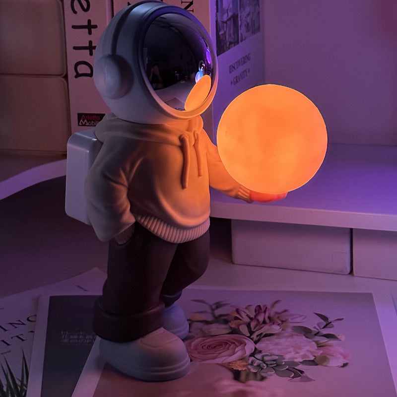 Holding the romantic moon beige top + brown pants Creative Astronaut Bluetooth Speaker with 3D Starry Sky Lighting, Portable Wireless Moon Lamp Speaker - Perfect Gift for Space Enthusiasts