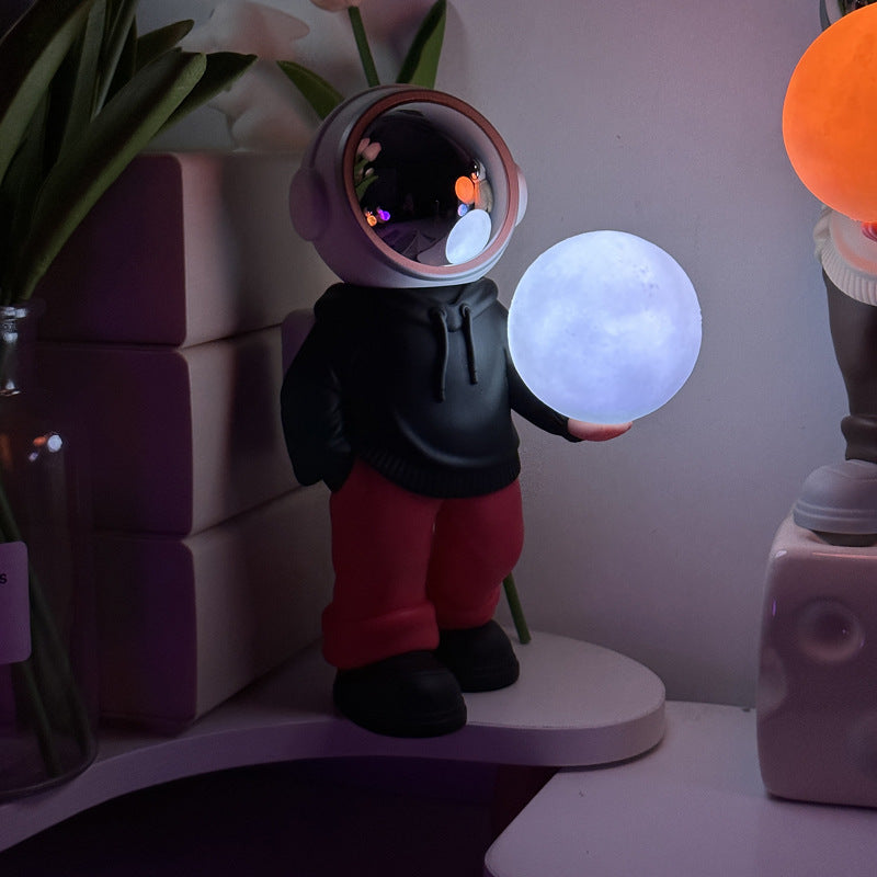 Holding the romantic moon black top + red pants Creative Astronaut Bluetooth Speaker with 3D Starry Sky Lighting, Portable Wireless Moon Lamp Speaker - Perfect Gift for Space Enthusiasts