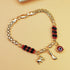 Gold-Tone Chain Bracelet with Red and Black Beads, Elephant Charm, Feather Pendant, and Round Stone Accent – 19 cm Length