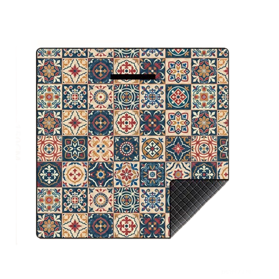 A square mat featuring a colorful vintage-style mosaic tile pattern, shown on a plain white background with one corner folded over to reveal a dark textured underside.